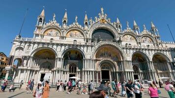 Venecia, Italia 03.08.2024 fachada de S t. marcas basílica en Venecia con turistas en el primer plano, el basílica grandeza es complementado por el claro azul cielo, mientras turistas en el primer plano añadir un video