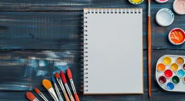 Blank Sketchbook and Paints On Wooden Table in Natural Light photo