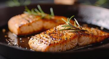 Grilled Salmon Fillets Garnished With Fresh Herbs on a Black Plate photo