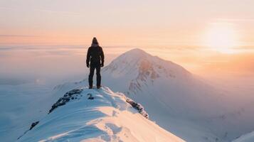 Hiker Standing on Snowy Peak at Sunrise in Mountain Range photo