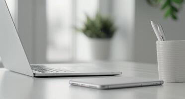 Modern Workspace With Laptop, Mug, and Potted Plant on White Desk photo