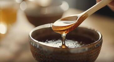 Drizzling Honey Into a Decorative Bowl Surrounded by Delicate Flowers photo