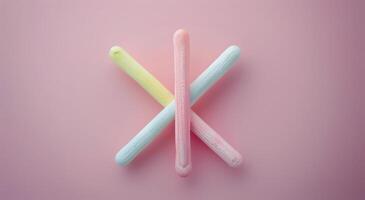 Colorful Candy Sticks Arranged on a Soft Pink Background photo