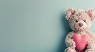 Adorable Teddy Bear Holding Pink Heart Against Soft Blue Background photo