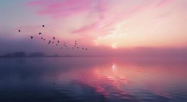 Glowing Sunrise Over Tranquil Lake With Birds in Flight photo