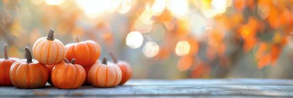 Pumpkins Gathered on Wooden Surface With Autumn Bokeh Background photo