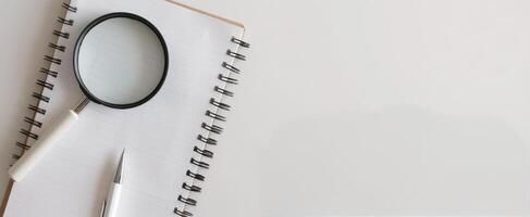 Magnifying Glass on Documents With Pink Pen in Brightly Lit Workspace photo