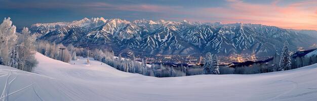 Snow-Covered Mountains at Dusk With Light Glowing in the Valley photo