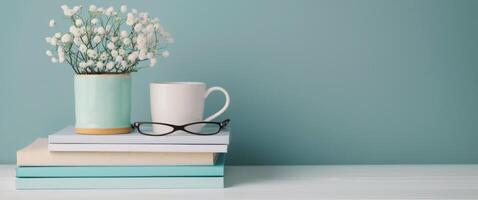 Pink Glasses Resting on Stacked Notebooks With Succulents in Background photo