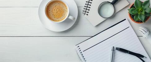 Magnifying Glass on Notepad With Pen and Succulent Plant on White Surface photo