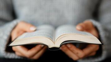 Hands on Open Book With Intricate Patterns in a Softly Lit Environment photo