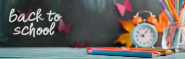 Back To School Themed Chalkboard With Colorful Pencils And A Clock photo