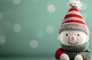 Festive Knit Snowman Ornament on Soft Green Background With Bokeh Lights photo