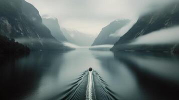 Rowboat Gliding Across Calm River at Dawn Near Misty Mountains photo