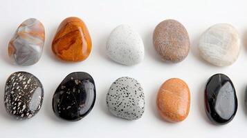 Colorful Variety of Polished Stones Displayed in a Row on a White Surface photo