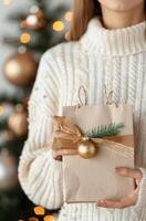 Christmas Gift Wrapped Elegantly in Front of Decorated Tree photo