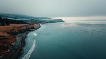 Serene Aerial View of Turquoise Waves Along Rugged Coastline in Daylight photo