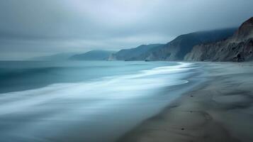 Calm Seaside Landscape With Rocky Shoreline and Snowy Mountains in Overcast Weather photo