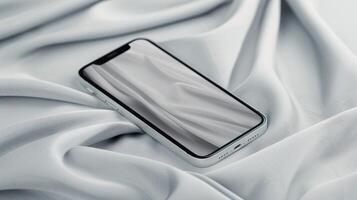 Mobile Phone Resting On Soft White Fabric In A Minimalist Setting photo