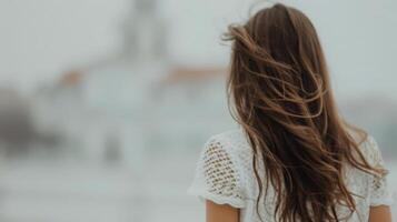Woman With Flowing Hair Facing a Historical Building on a Overcast Day photo