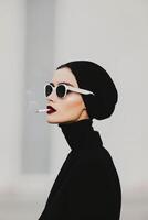 Elegant Woman in Black Attire Smoking With Stylish Sunglasses Outdoors photo