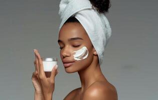 Woman Holding Jar of Cream With Towel on Head photo