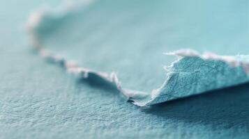 Close-Up View of Frayed Fabric Edge on Soft Blue Material photo