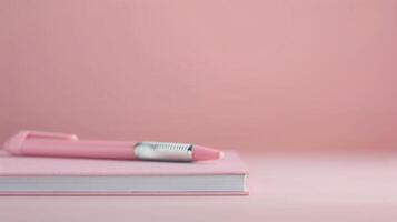 Pink Notebook and Pen on Soft Pink Surface in Minimalist Setting photo