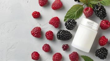 Raspberries and Blackberries Surrounding a White Container on Light Gray Surface photo