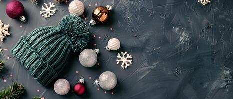 Green Knit Hat Surrounded by Christmas Ornaments and Snowflakes on Dark Background photo
