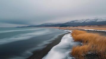 Winter Landscape of Black Sand Beach and Snow-Covered Cliffs in Iceland photo