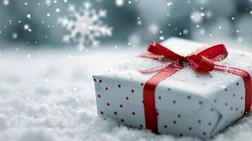 Wrapped Christmas Gift on Snowy Ground With Falling Snowflakes photo