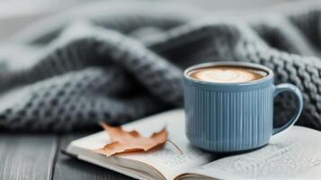 Cozy Autumn Moment With Hot Beverage, Knitted Blanket, and Leaves on a Table photo