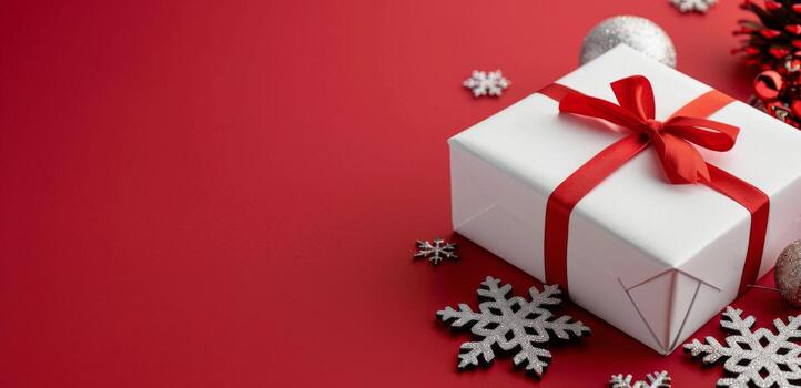 Festively Wrapped Gift Box With Red Bow on a Red Background With Snowflakes photo