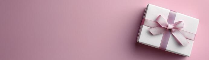 Wrapped Gift With Pink Bow on Soft Pink Background photo