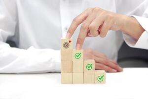 Two fingers of a businessman is walking up stairs wooden blocks. Concept of Success, progress and growth. photo