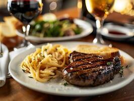Grilled steak with pasta and garlic bread, paired with a glass of red wine, evokes a rich and indulgent dining experience photo