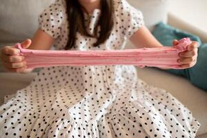 Girl Stretching Slime. Girl Playing with Pink Slime photo