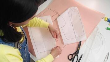 Seamstress combines various patterns to create a unique collar design for their designer clothing. video