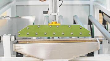 With the aid of automation, a metal sheet is introduced into a machine designed for the purpose of joining metal furniture components using adhesive. video