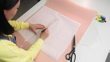 Artist, armed with a ruler and marker, begins the process of creating a design concept for a future clothing line on a blank piece of paper. video