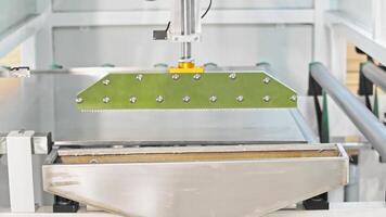 Detailed view of a machine meticulously applying adhesive to furniture components, ensuring an even distribution for optimal results. video