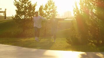 Young couple is frolicking, gamboling and cavorting in the park at sundown, they are enamored. video