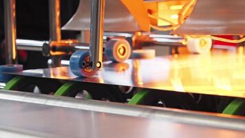 Metal sheet enters the packaging machine through the use of large wheels located within the machine. video