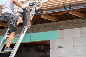 a worker carries a ceramic tile up the stairs to the roof photo
