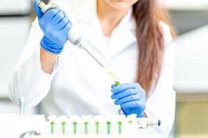 dropper dosing of chemical samples into flasks for research in a scientific laboratory photo