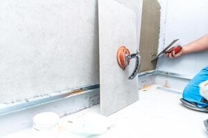 installation of large format tiles on the wall by a craftsman photo