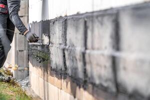 waterproofing of the wall with a covered asphalt belt during the construction of the building photo