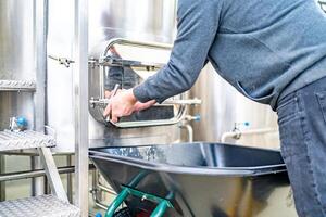 cleaning the boiler from residual malt after brewing beer in the brewery photo