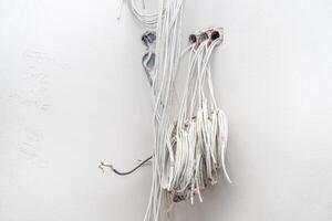 bundle of wire in the wall to connect the smart home. preparation for the Internet, sound system and room lighting photo